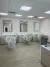 Empty salon room with mirrors, chairs wrapped in plastic, and a wood floor under fluorescent lights
