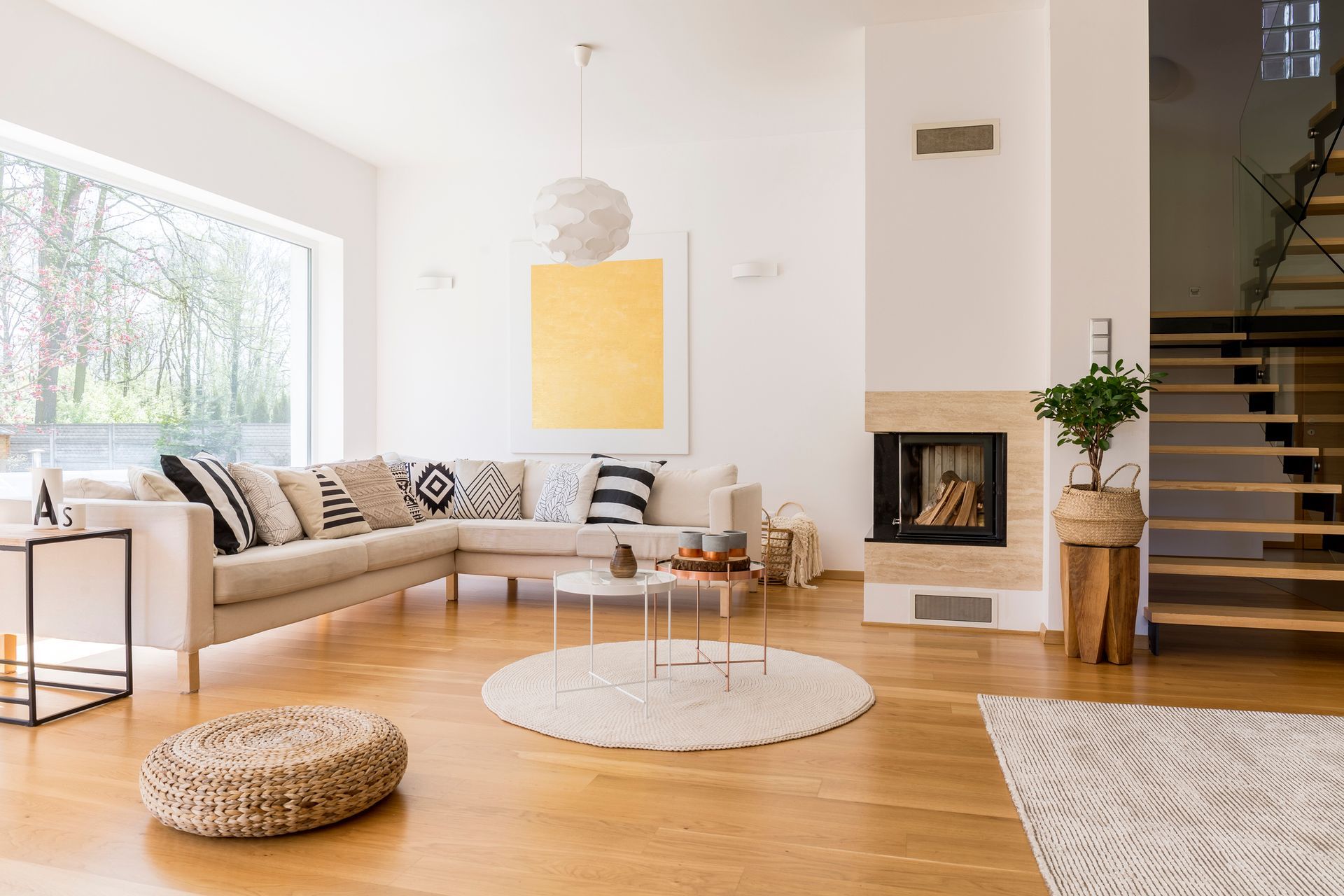 A living room with a couch , coffee table , fireplace and stairs.
