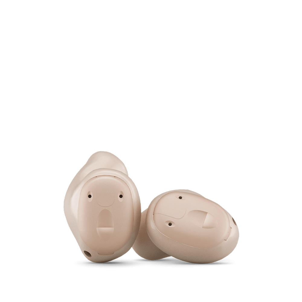 A pair of hearing aids sitting next to each other on a white background.