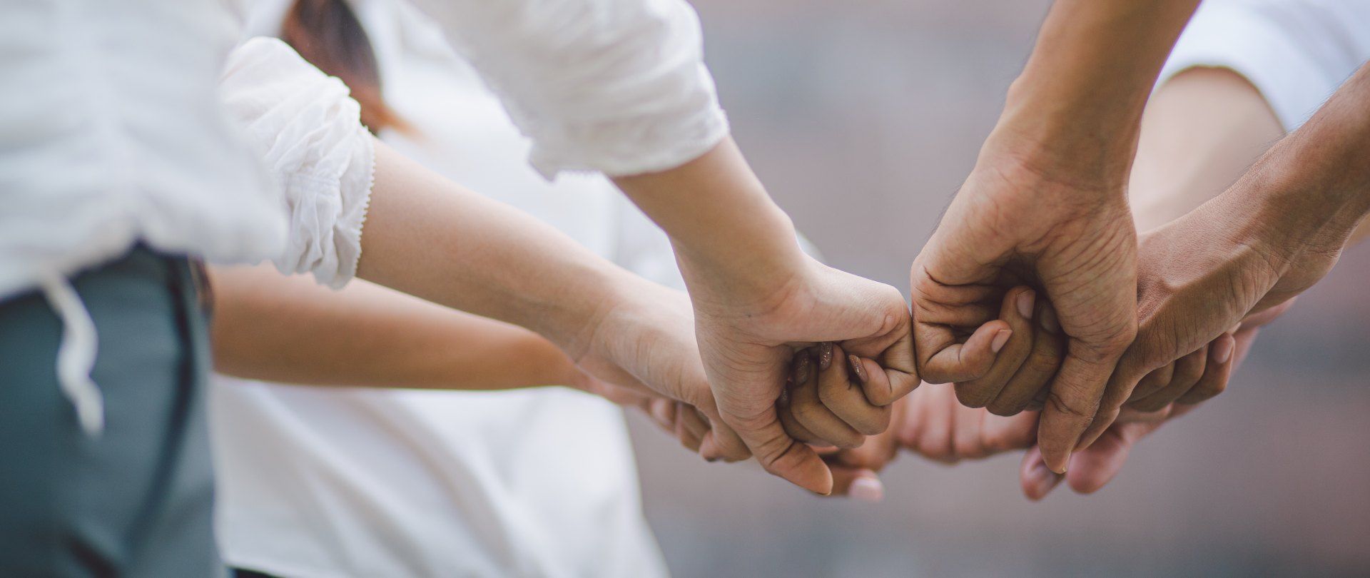 a group of people are holding hands in a huddle.