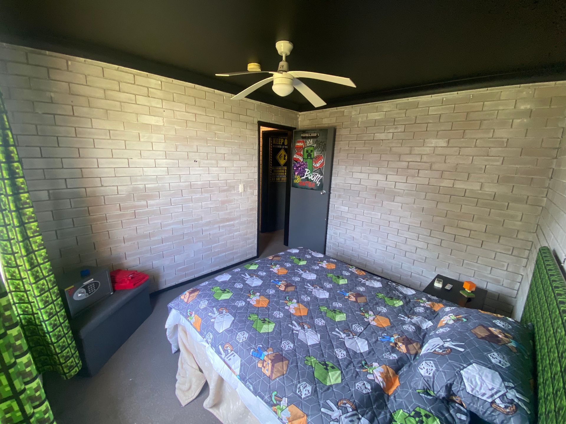A bedroom with a bed and a ceiling fan.