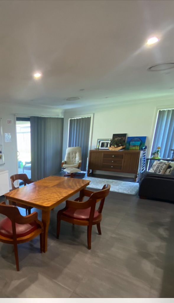 A living room with a table and chairs and a couch.