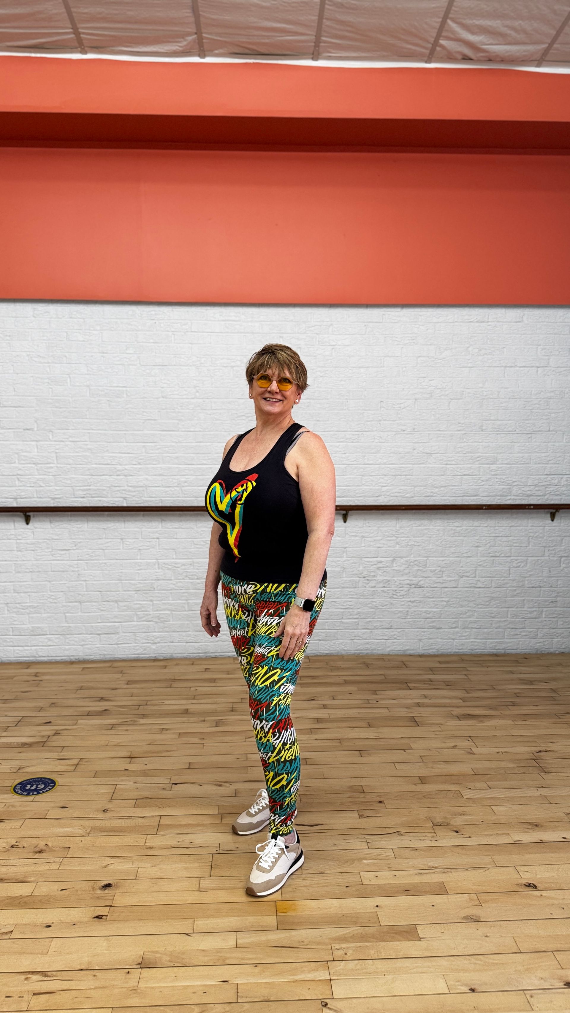 A women with boxing gloves leaning on a kickboxing bag