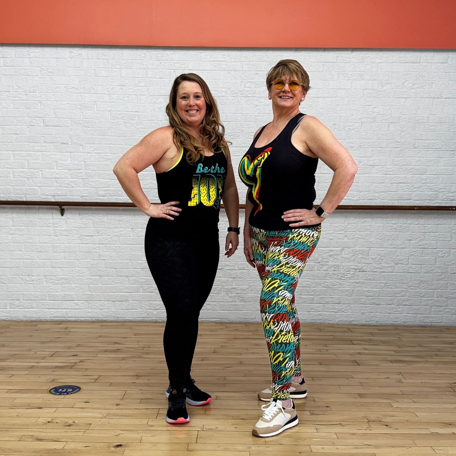 Two women are standing next to each other in a dance studio.