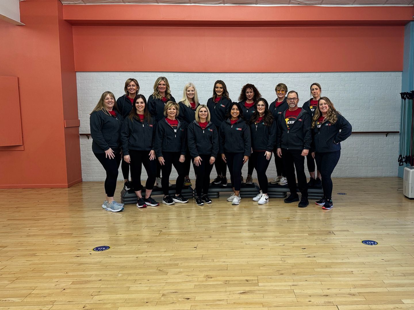 A group of women are posing for a picture in a dance studio.