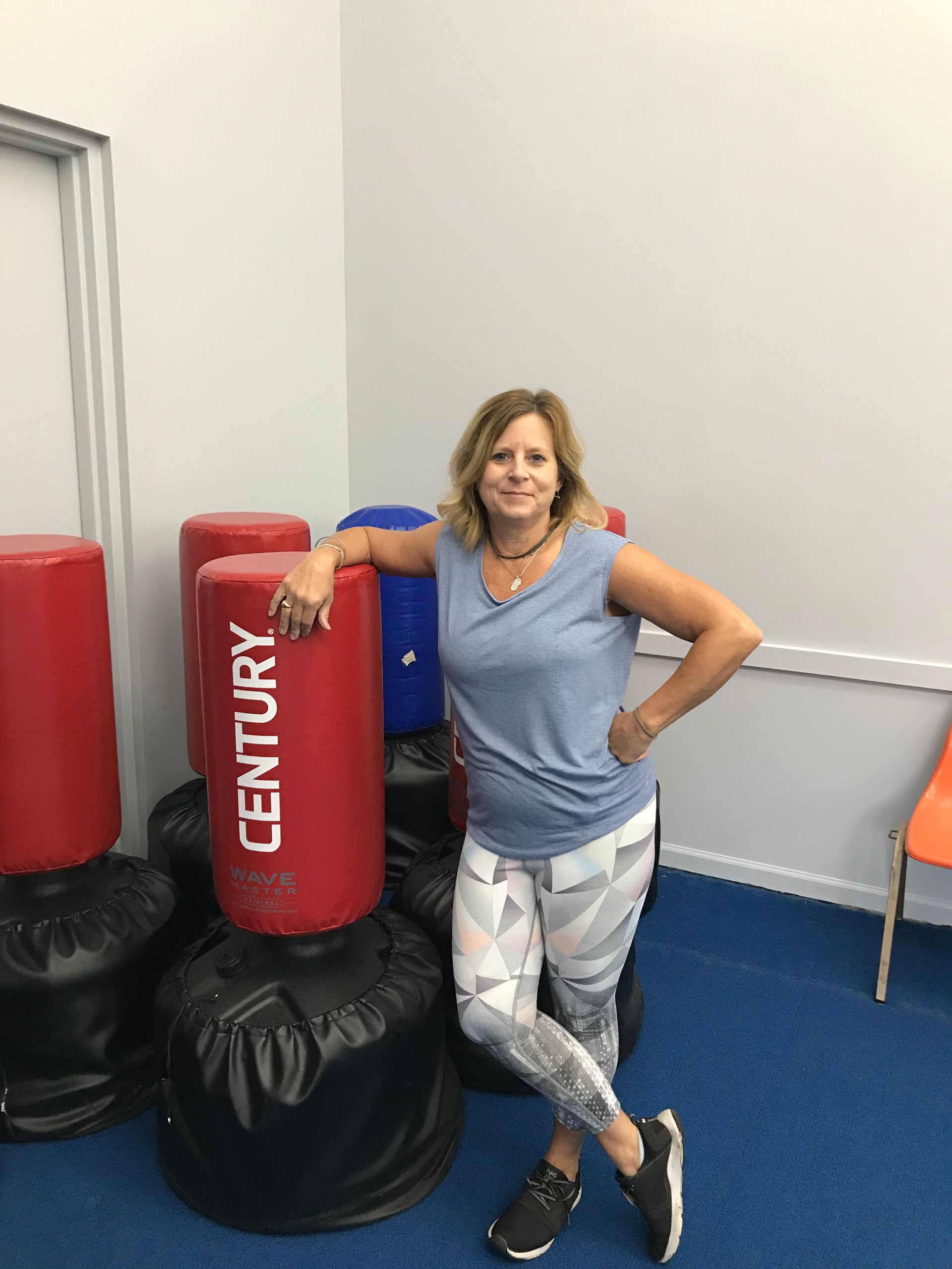 A women leaning on a kickboxing bag