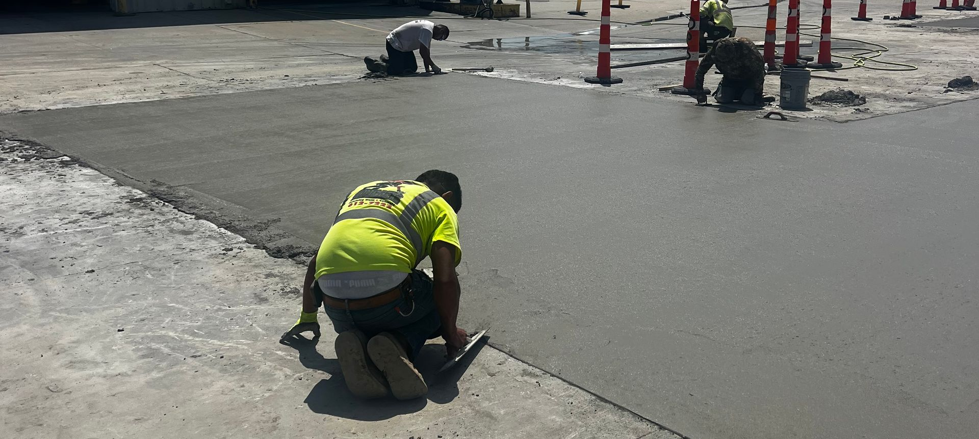 Concrete contractor applying cement with a trowel. Concrete driveway contractor applying cement with a trowel.