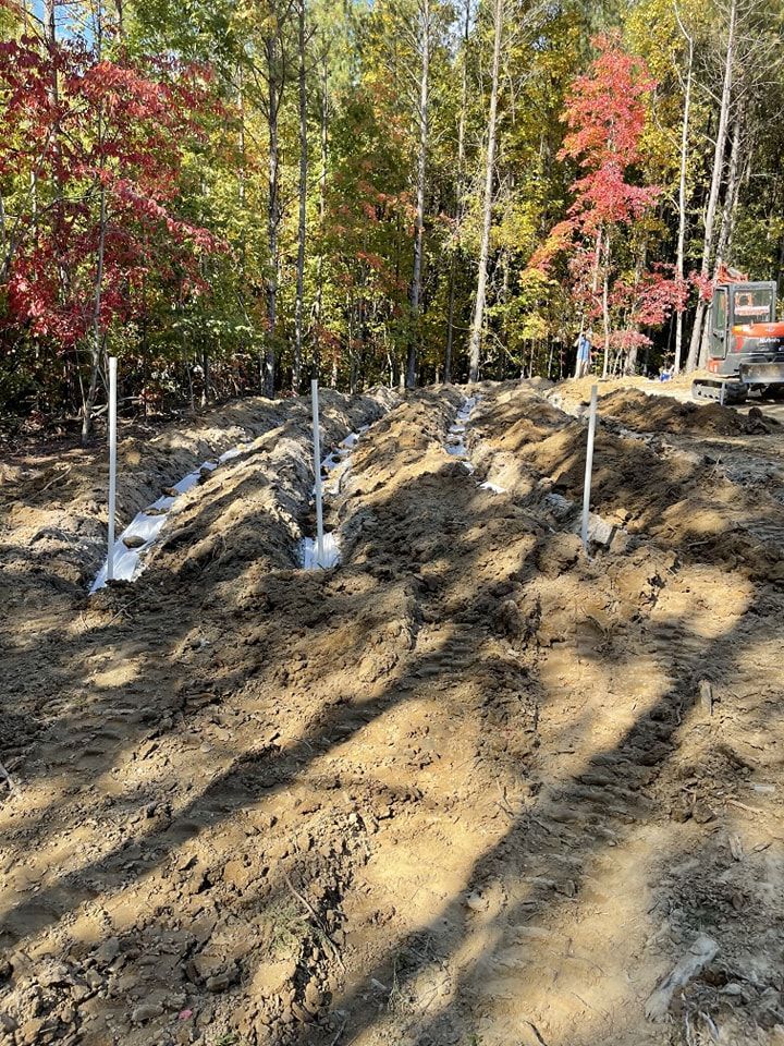 A pile of dirt with shovels in it in the middle of a forest.