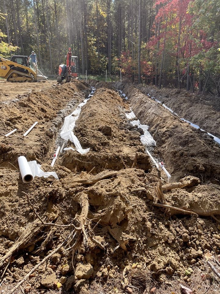 A large pile of dirt and pipes in the middle of a forest.