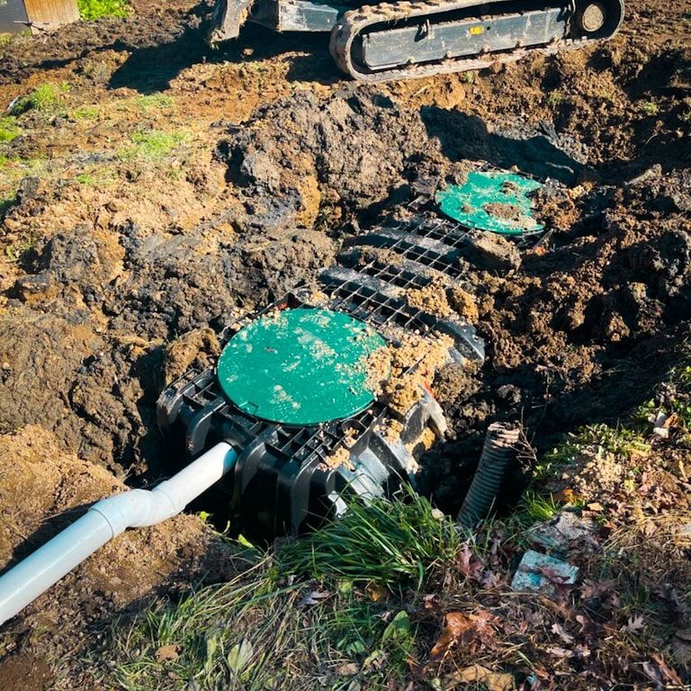 A septic tank is being installed in the dirt next to a bulldozer.