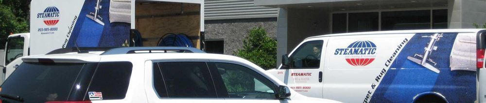 Vehicles with logos parked outside a building.