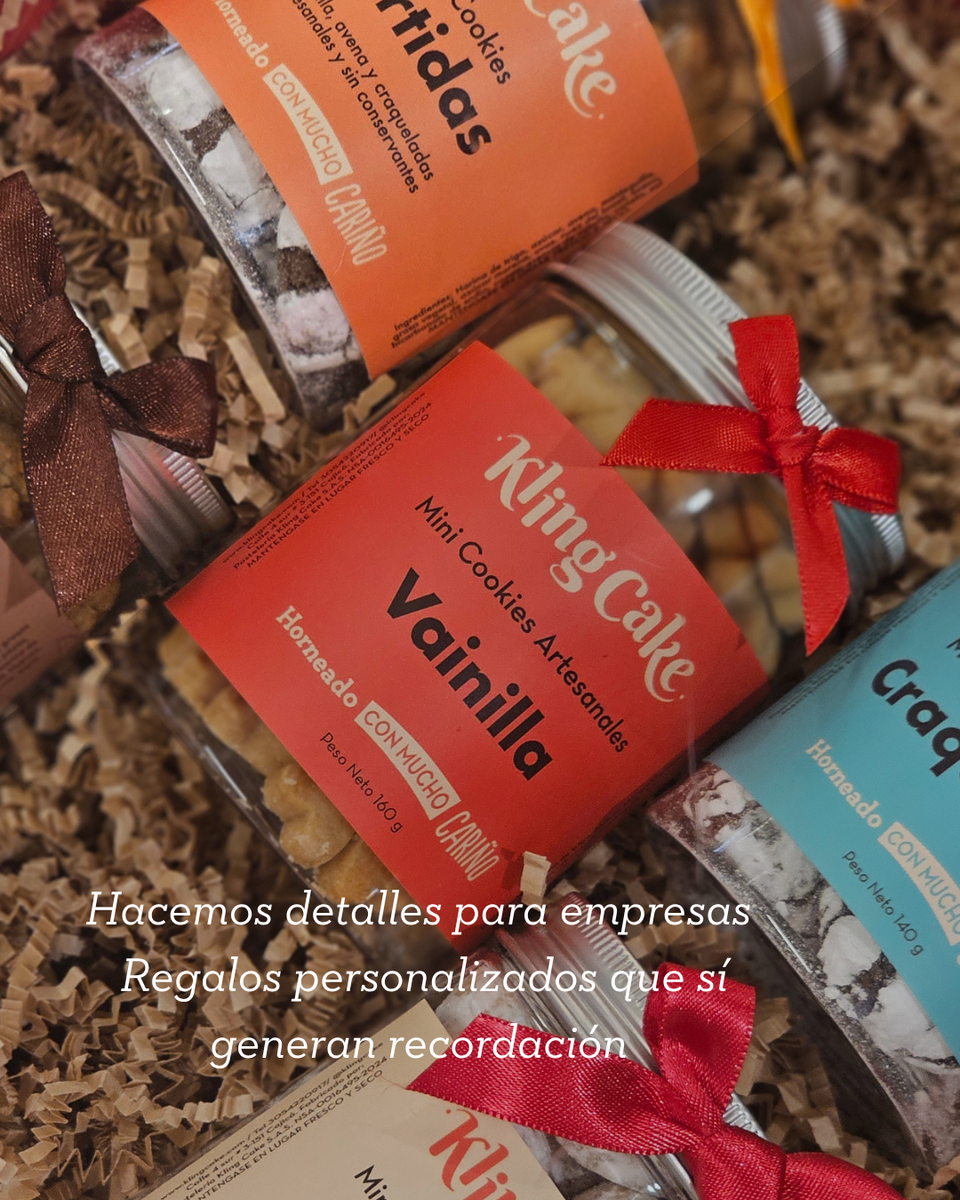 Tarros de mini cookies personalizados con etiquetas rojas, naranjas y azules sobre una superficie de madera rústica.