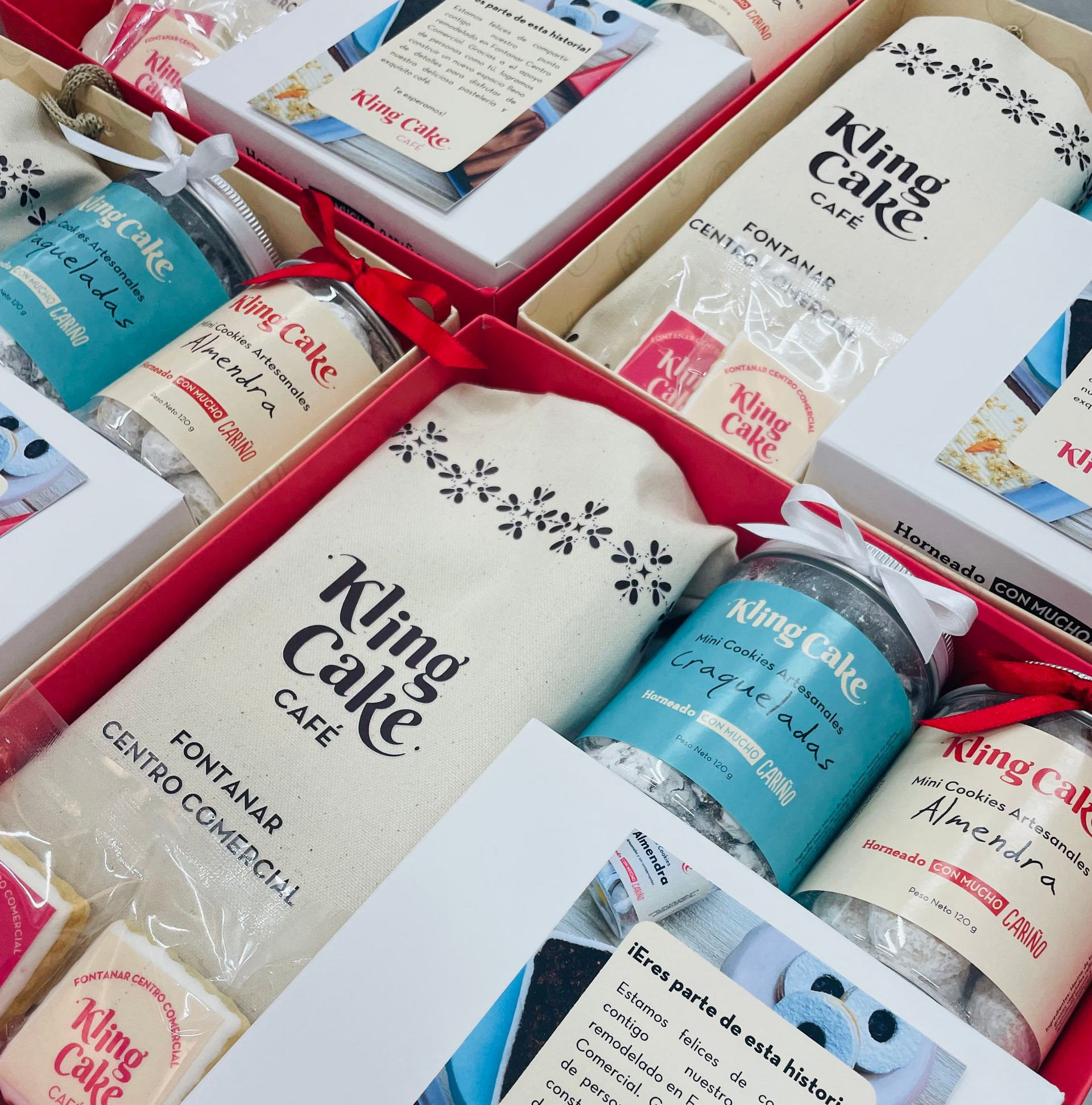 Surtidos sets de regalo para el cuidado de la piel en cajas rojas con frascos blancos y azules y tarjetas.