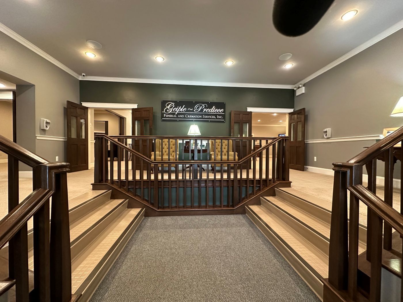 A hallway with stairs leading up to the second floor of a building.