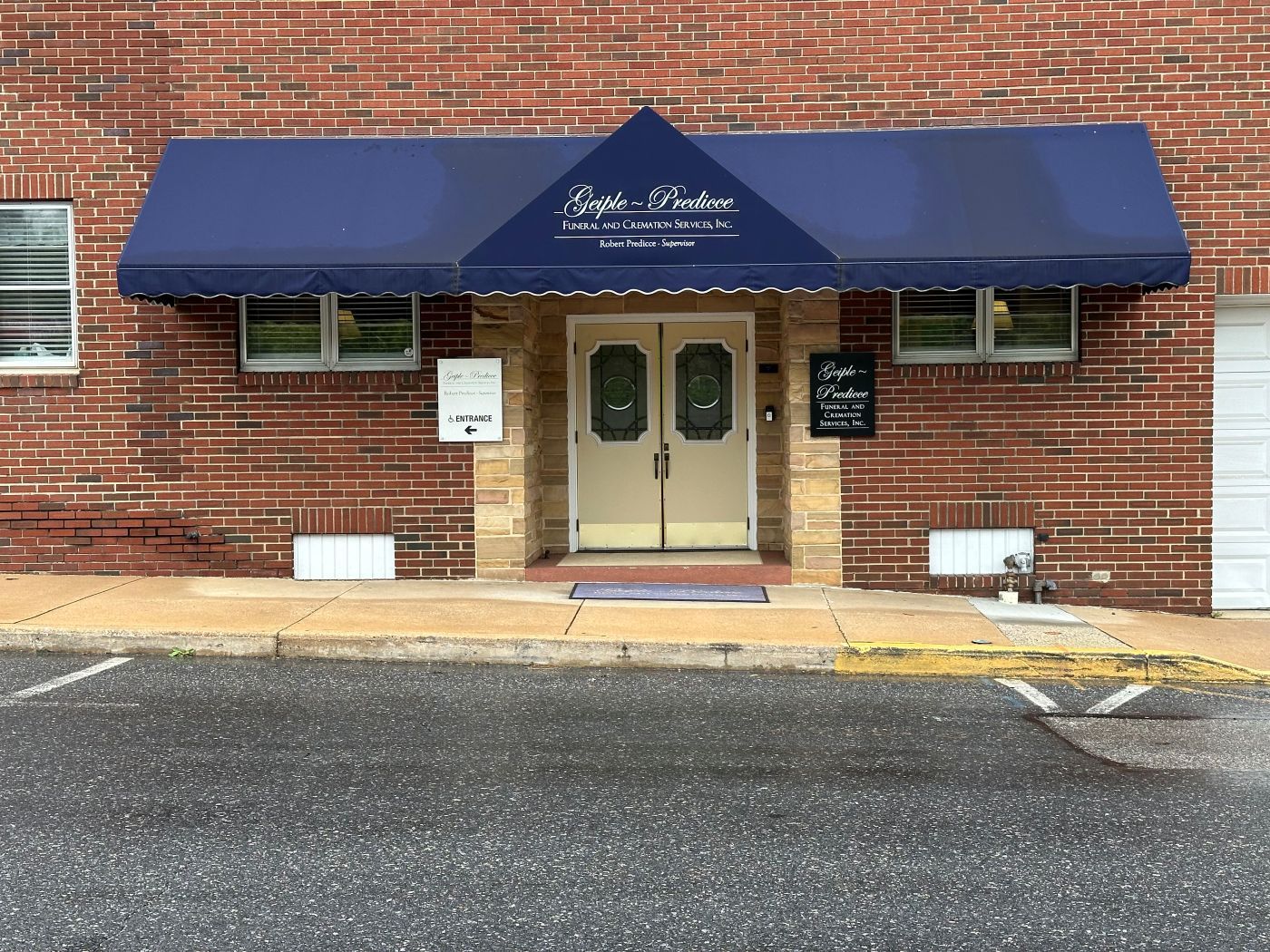 A brick building with a blue awning over the entrance