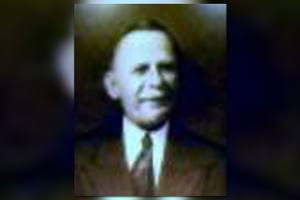 A black and white photo of a man in a suit and tie