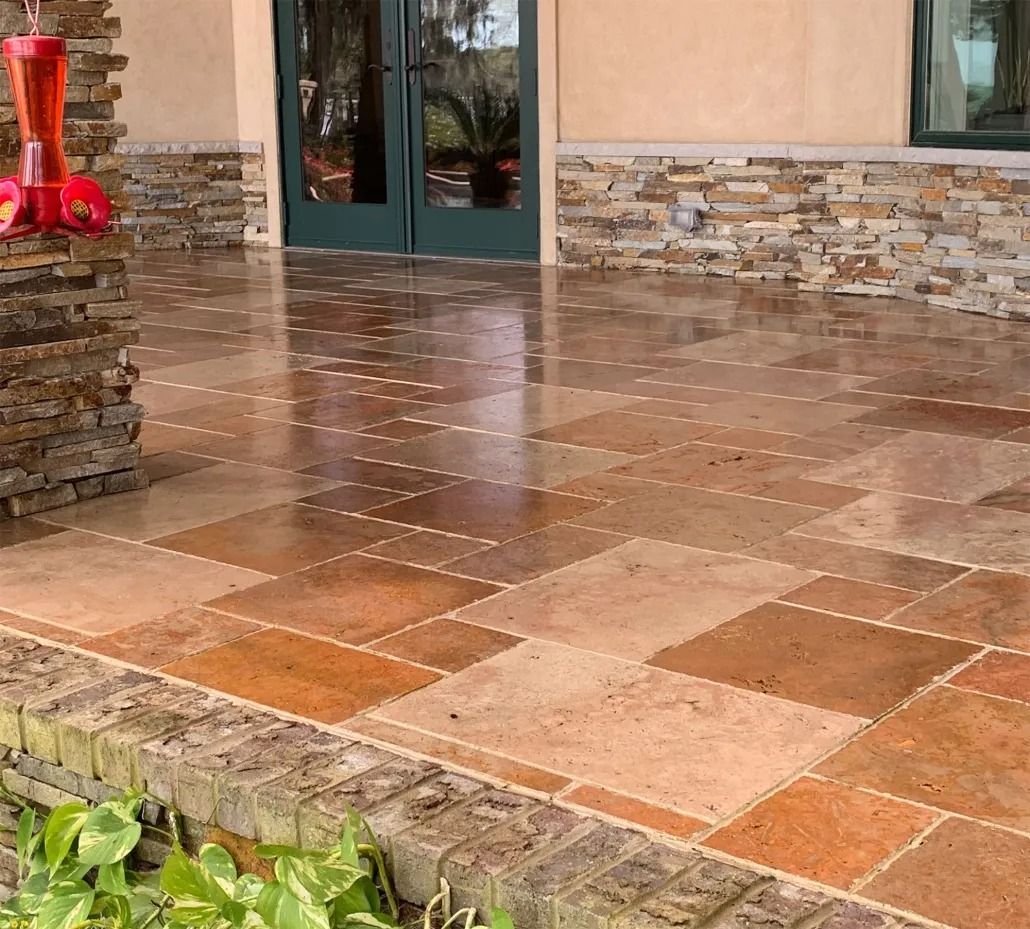 Wet tiled patio with stone columns and a doorway