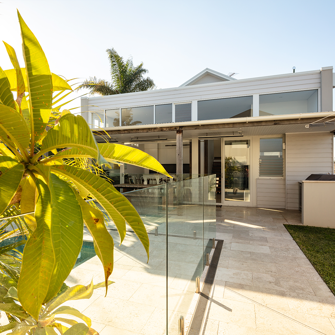 Large Beige House With a Red Tile Roof and Balconies Overlooking a Tennis Court — Burmah Constructions in Nowra, NSW