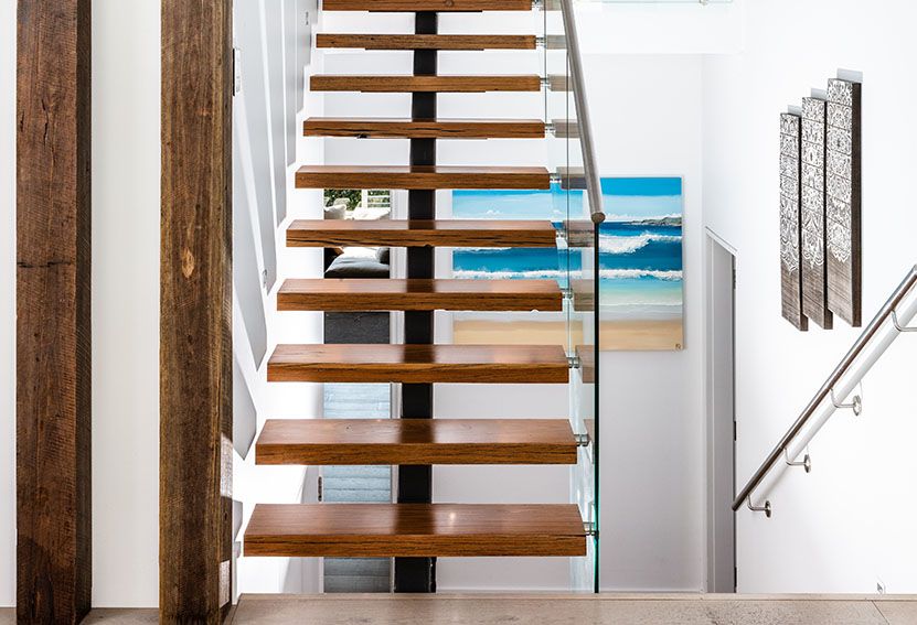 Wooden Floating Staircase With Glass Railing, White Walls, and Artwork — Burmah Constructions In Kangaroo Valley, NSW