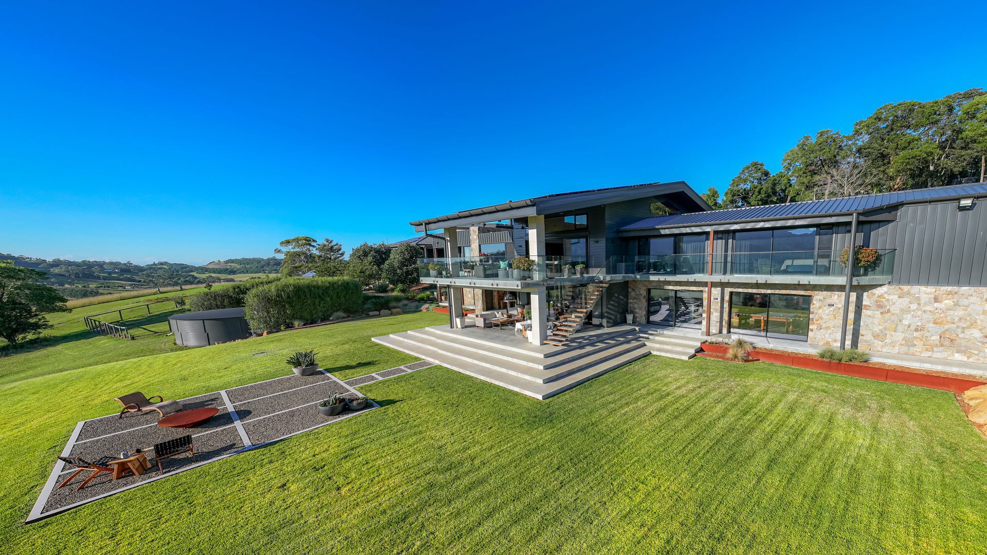 Modern House With Glass Walls, Stone Exterior, and Large Green Lawn — Burmah Constructions In Kangaroo Valley, NSW