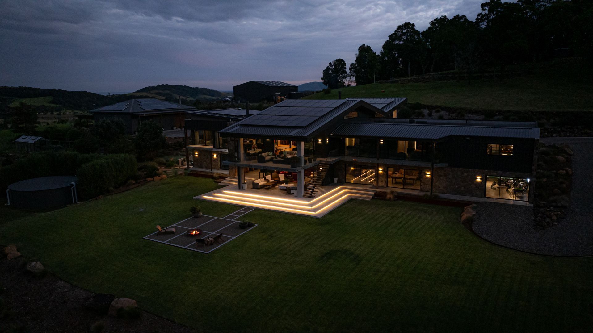 Modern House With Warm Lights at Dusk, Set on a Grassy Hillside — Burmah Constructions In Kangaroo Valley, NSW