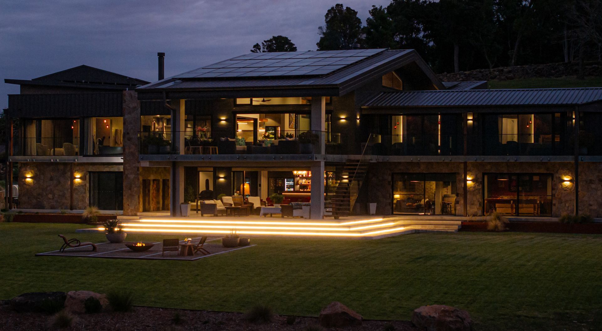 Modern Two-story House at Dusk With Warm Lights Glowing Through Large Windows — Burmah Constructions In Kangaroo Valley, NSW