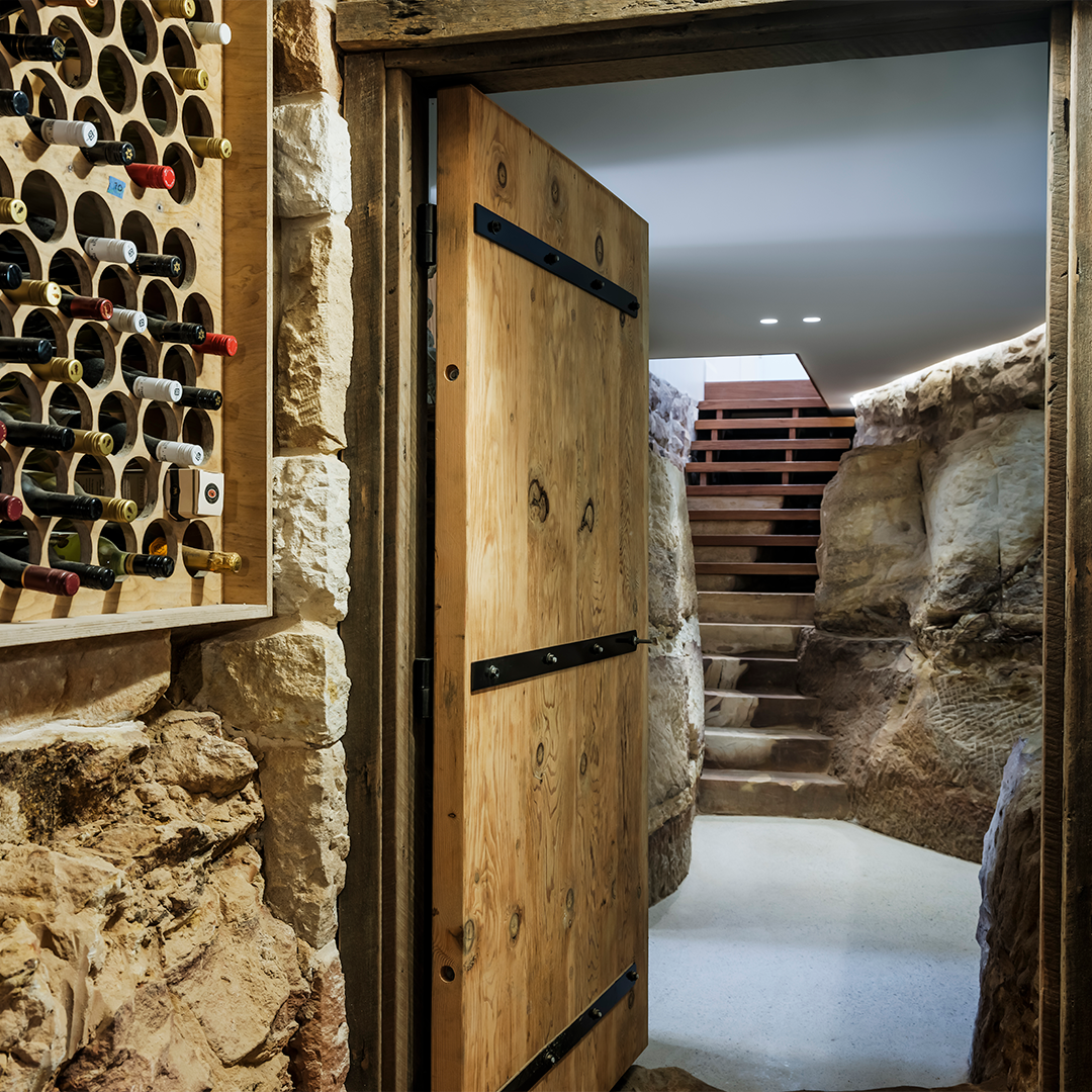 Wine Cellar Entrance With Wooden Door, Stone Walls, Wine Rack, and Staircase — Burmah Constructions In Kangaroo Valley, NSW