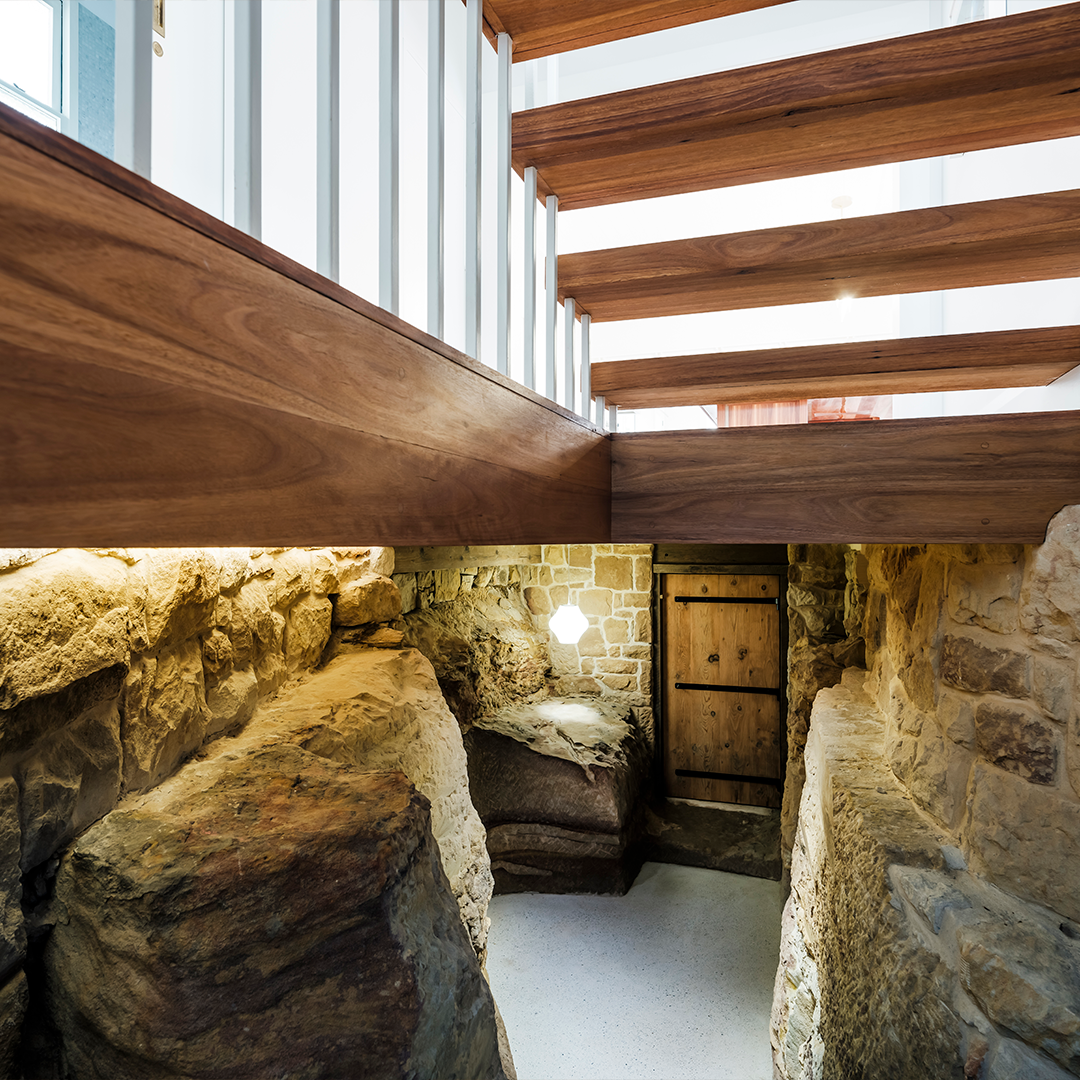 Wooden Beams Frame a Window. Below, a Stone Passage Leads to a Wooden Door — Burmah Constructions In Kangaroo Valley, NSW
