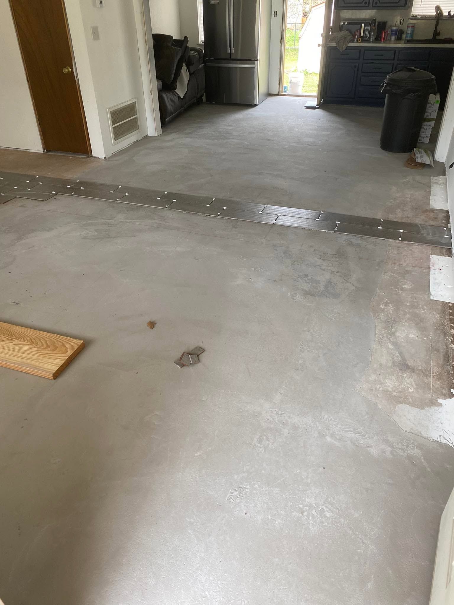 Concrete garage floor with a raised crack or seam across the middle, leading toward an open doorway.