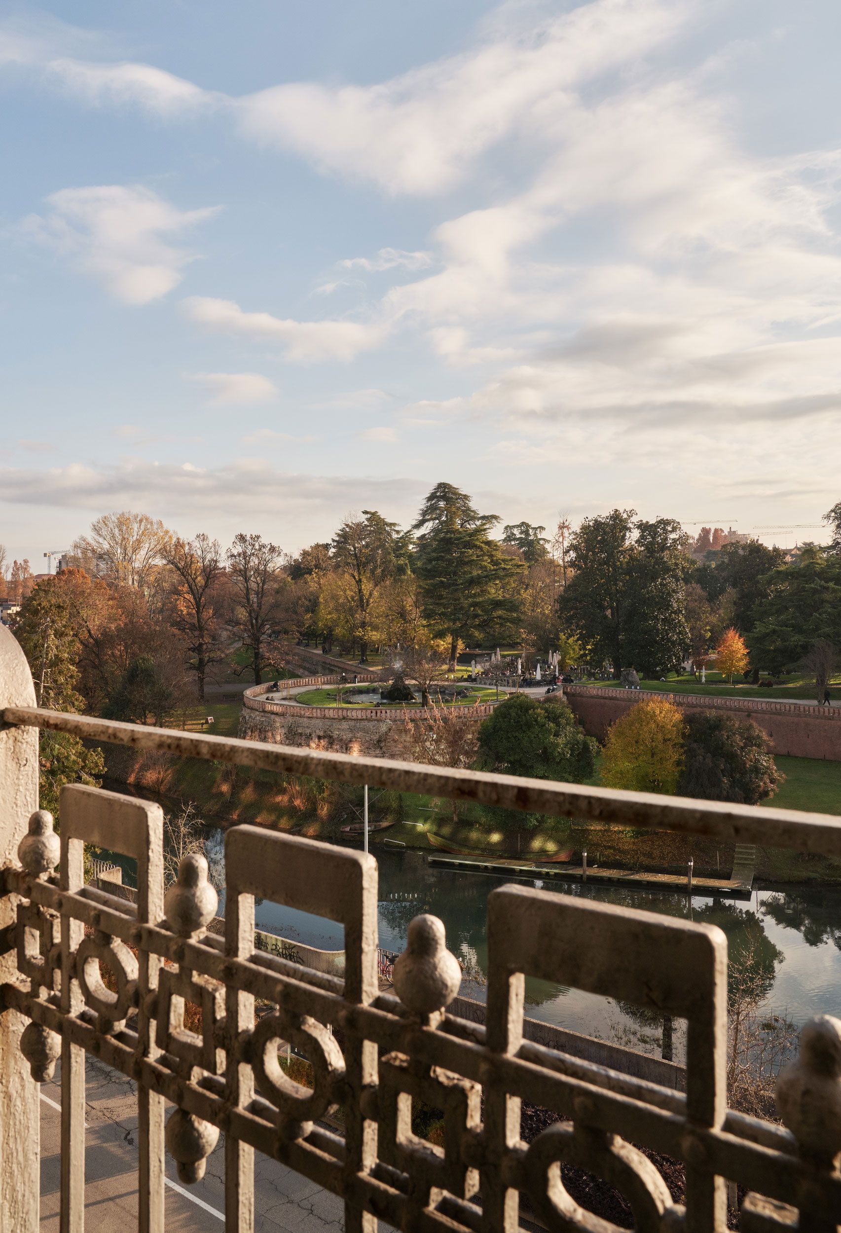 Vista dal balcone di alberi e di un fiume sotto un cielo azzurro nuvoloso in autunno.