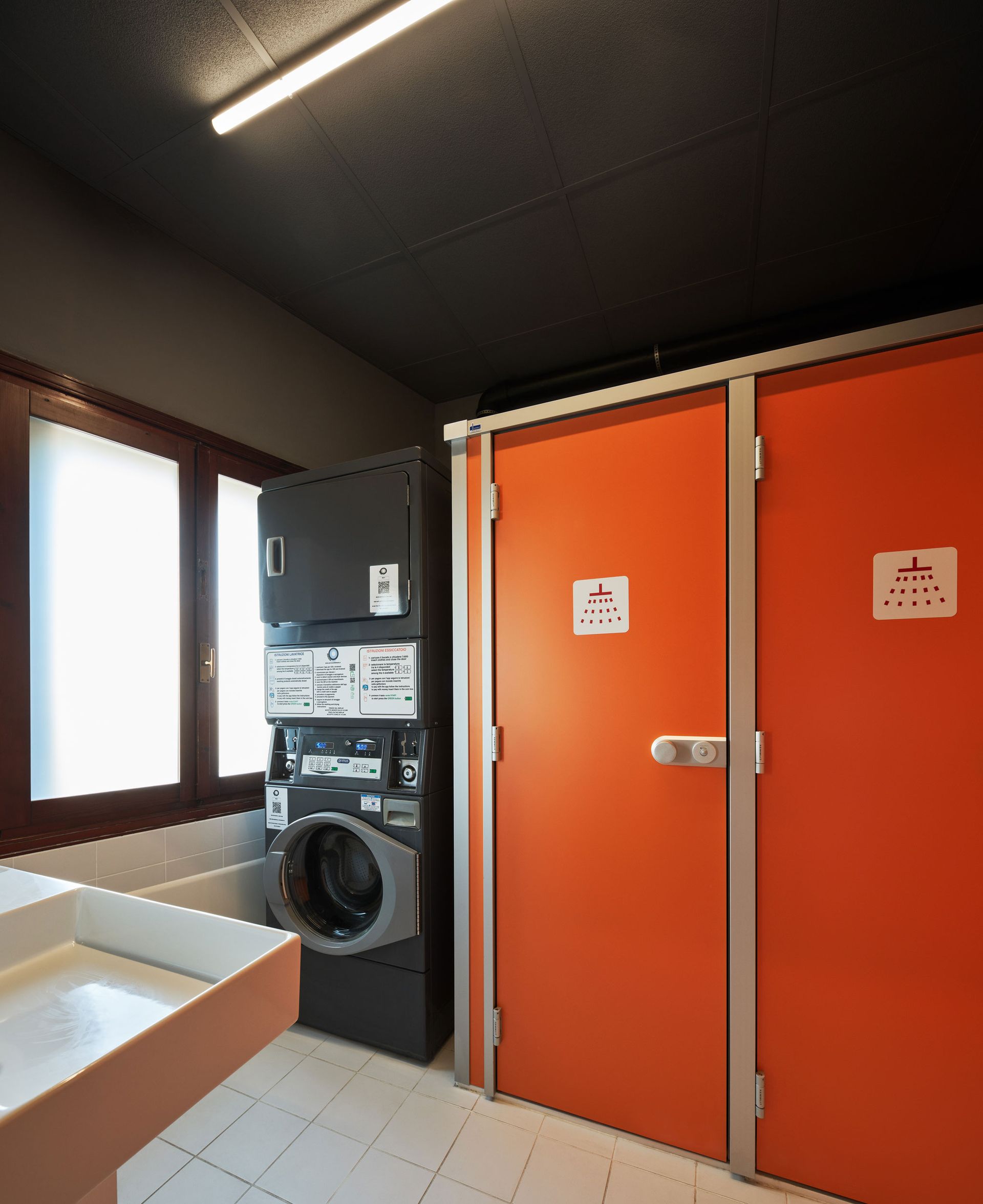 Lavanderia con porte arancioni, lavatrice e lavandino.