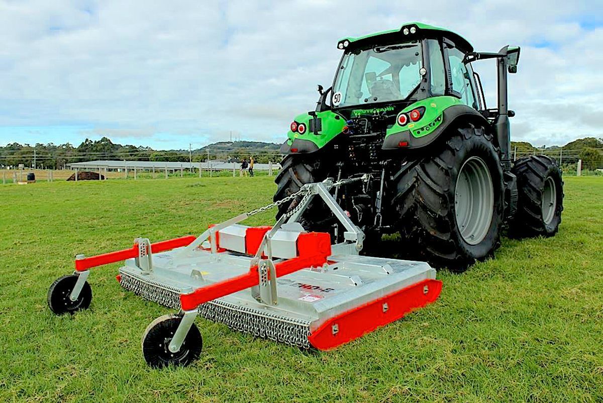 A Tractor Is Spraying a Field with A Sprayer Attached to It — Thompson's Farm Gear In Taree, NSW