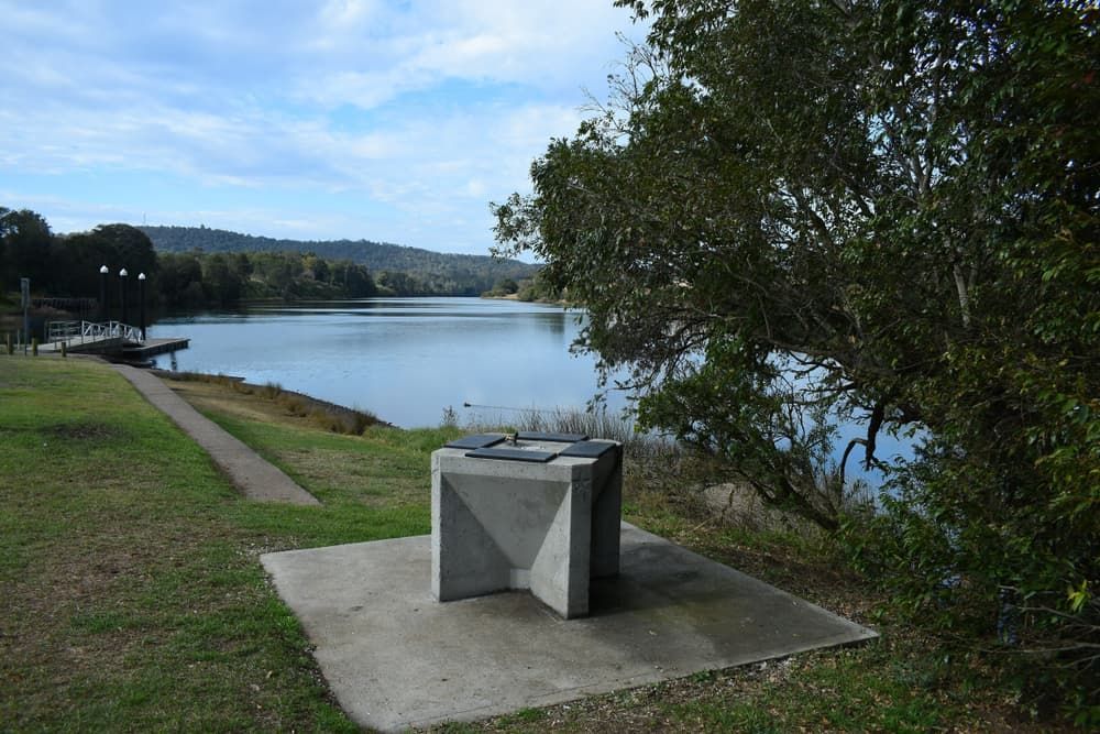 A Small Concrete Table Is Sitting Next to A Lake — Thompson's Farm Gear In Wingham, NSW