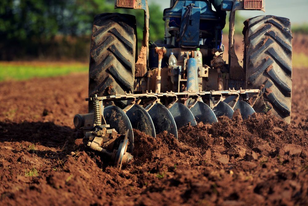 Agricultural Workers Operating Tractor for Cultivation — Thompson's Farm Gear In Coffs Harbour, NSW