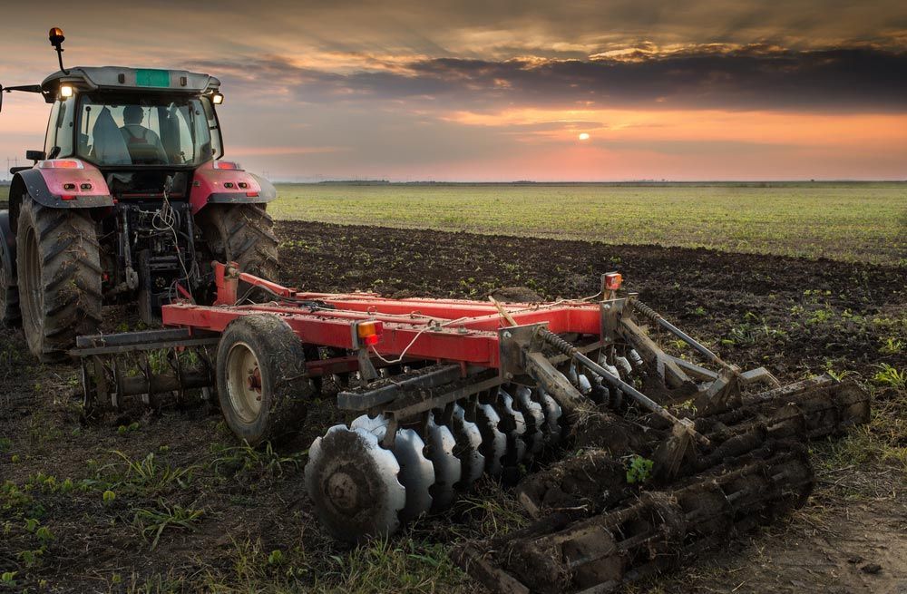 Farmer Operating Cultivation and Seeding Tractor — Thompson's Farm Gear In Wingham, NSW