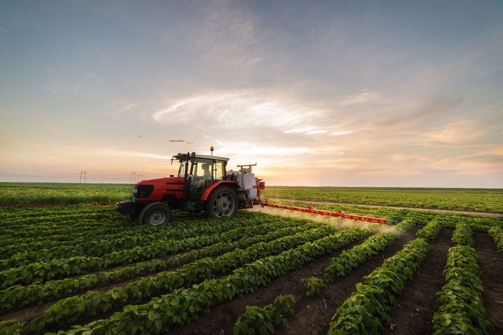 Farmer Applying Fertilizer to His Agricultural Land — Thompson's Farm Gear In Coffs Harbour, NSW