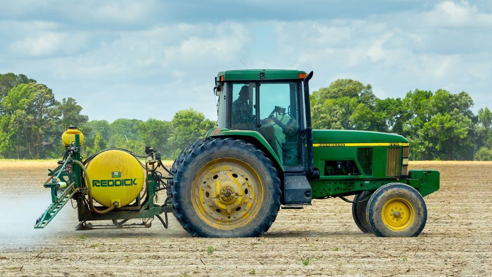 Green and Yellow Tractor on Dirt — Thompson's Farm Gear In Taree, NSW