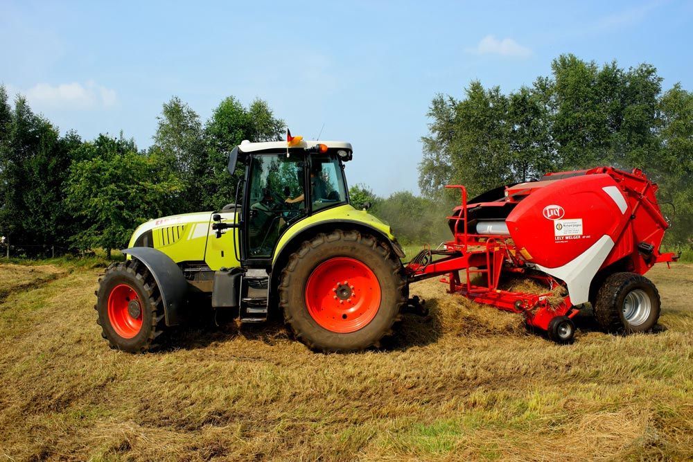Hay Machinery Paired with Tractor in Action — Thompson's Farm Gear In Wingham, NSW
