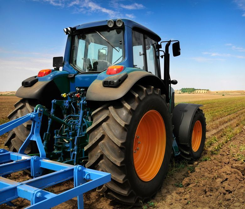 Large Blue Tractor in the Field — Thompson's Farm Gear In Port Macquarie, NSW