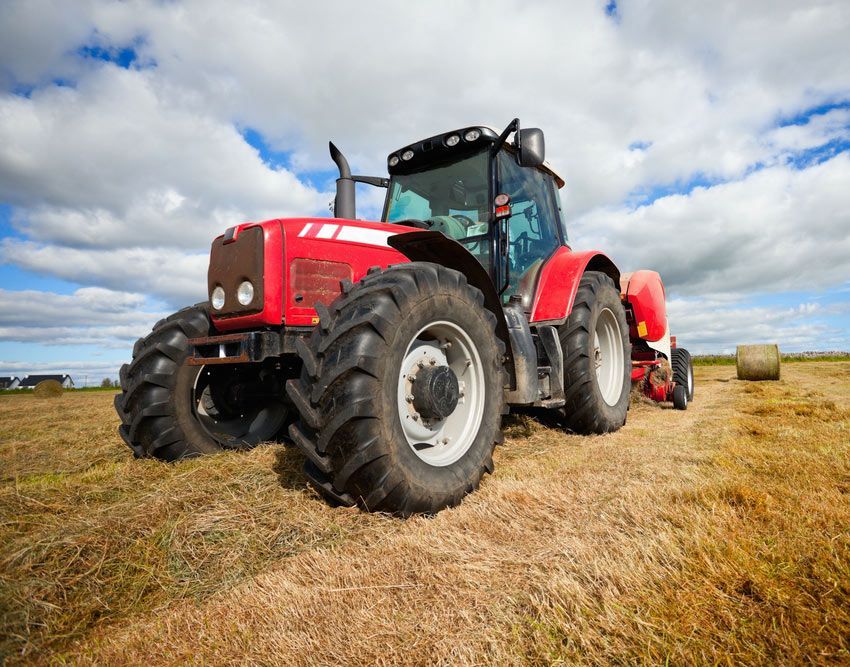 Huge Tractor Collecting Haystack in the Field on a Beautiful Sunny Day — Thompson's Farm Gear In Port Macquarie, NSW