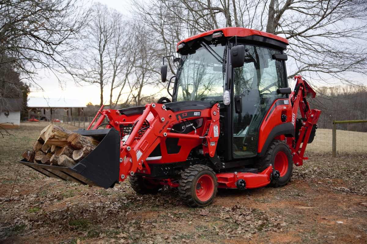 Red Tractor With Front Loader Parked In A Muddy Yard — Thompson's Farm Gear In Wauchope, NSW