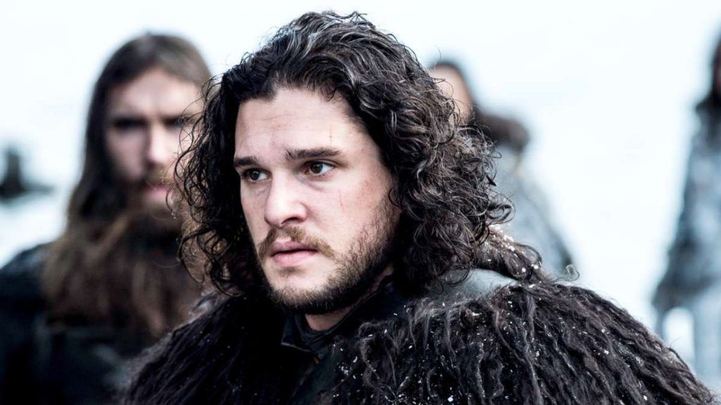 A man with long hair and a beard is wearing a fur coat.