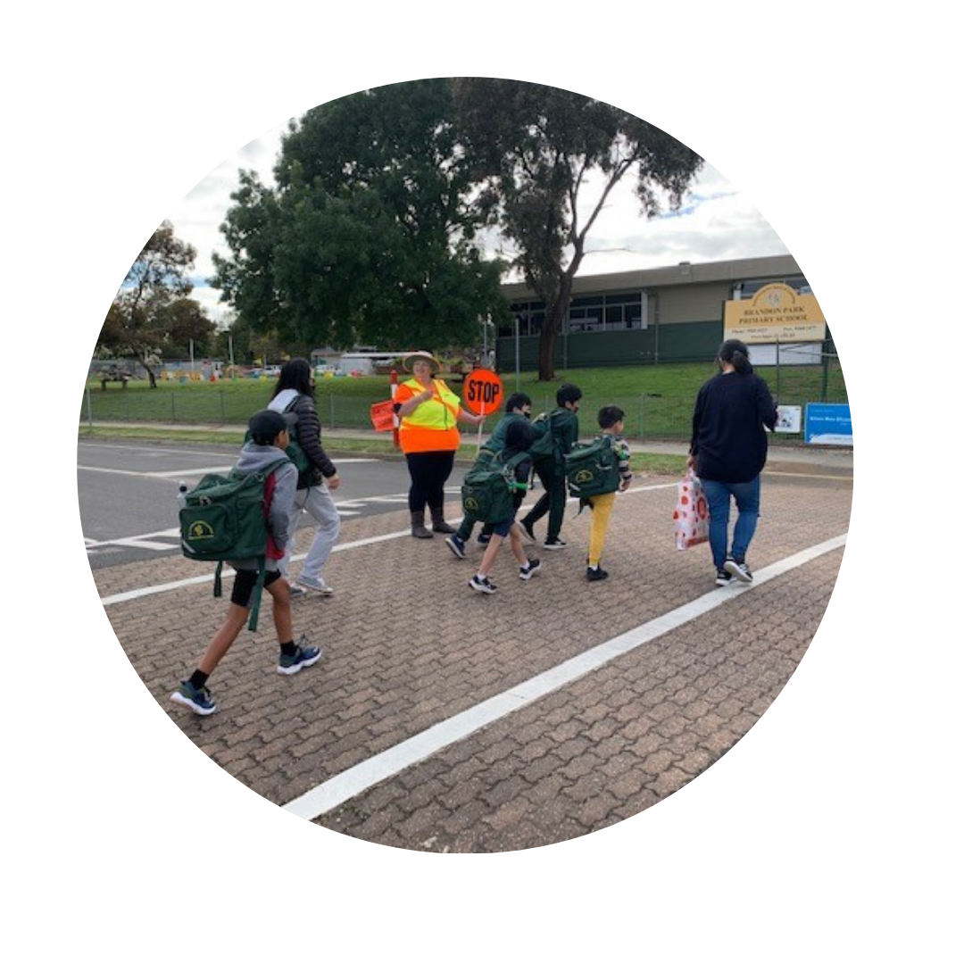 A group of people crossing a street with a stop sign in the background