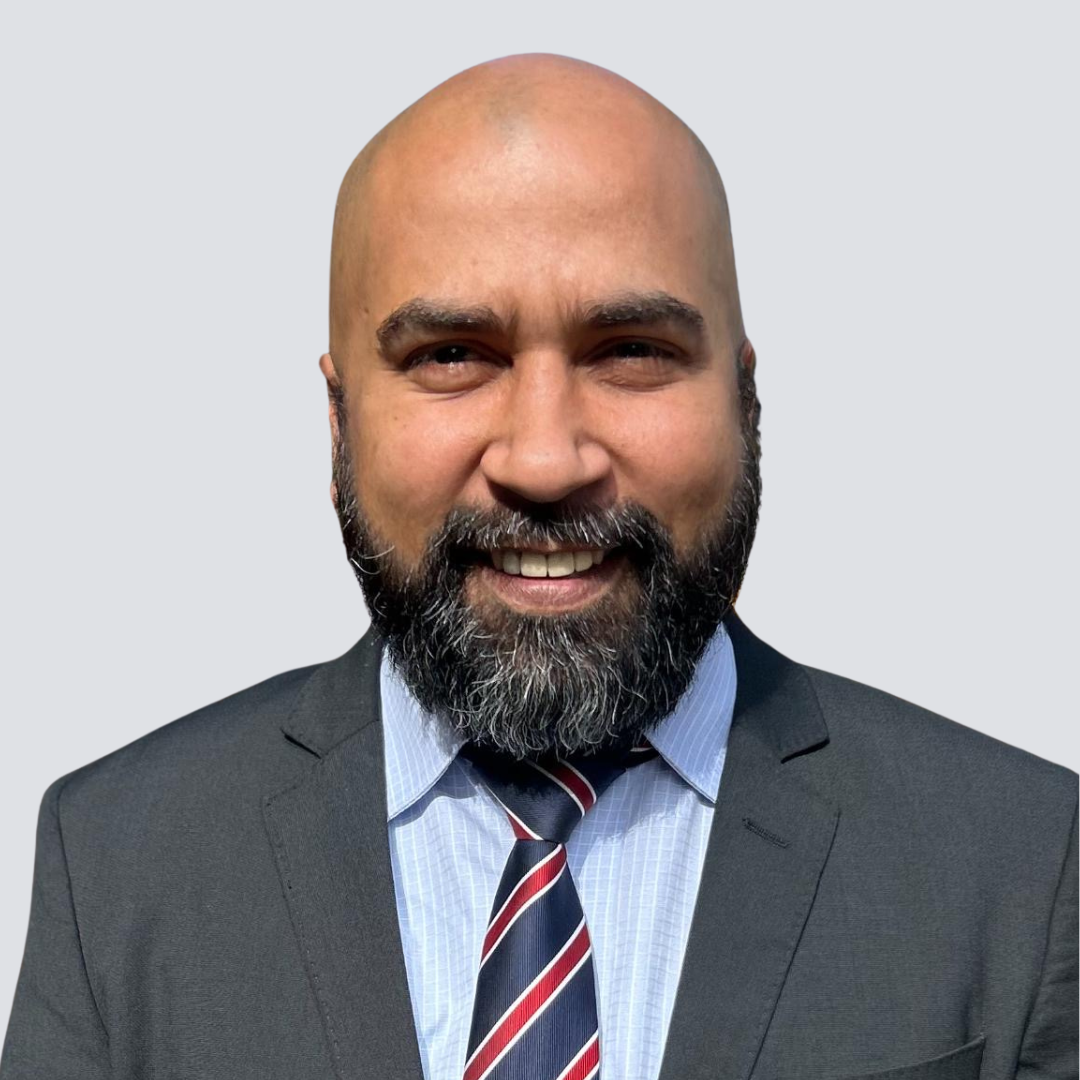 A bald man with a beard wearing a suit and tie