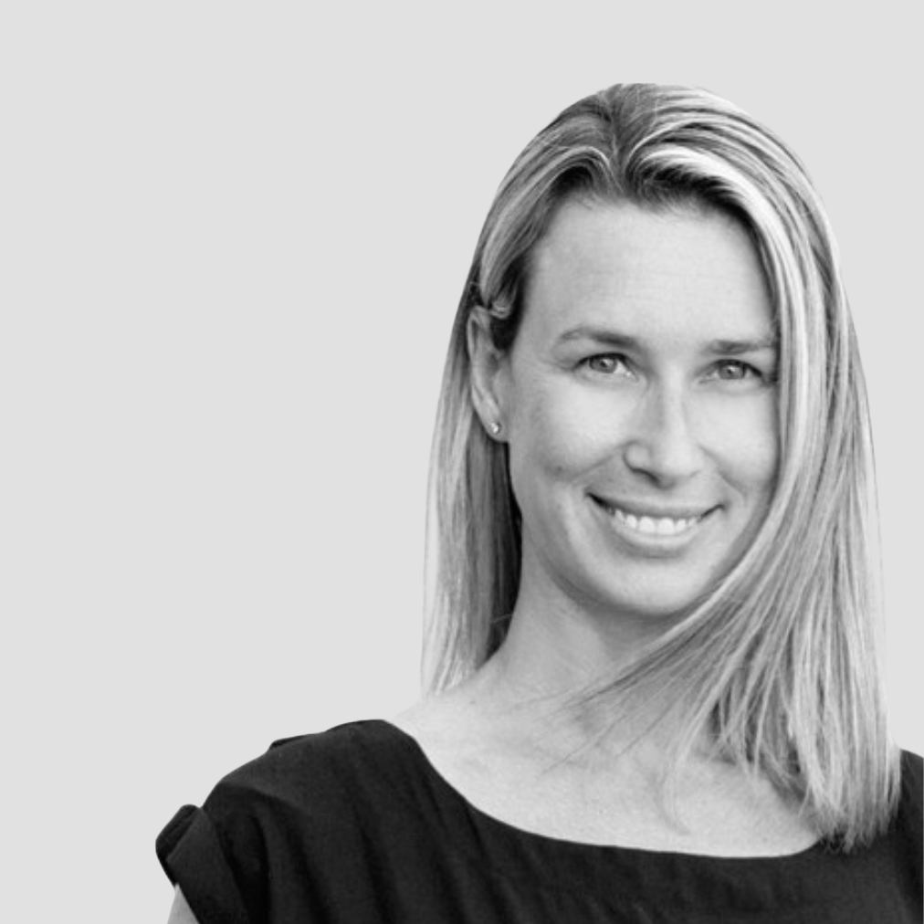 A woman in a black dress is smiling in a black and white photo