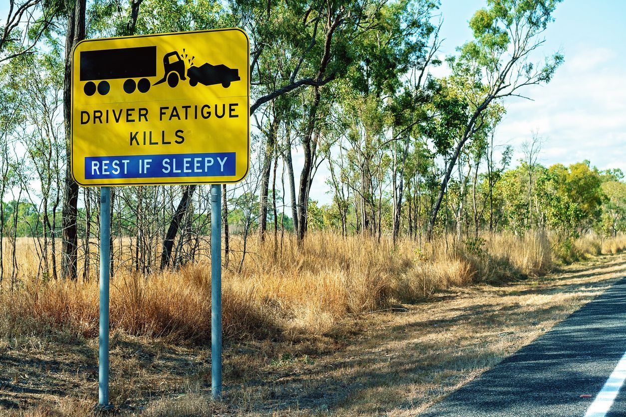 Yellow road sign with truck icon, text: