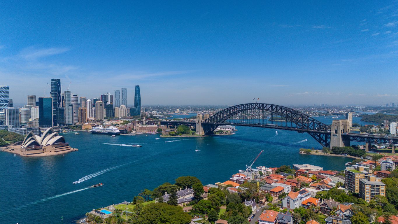 Sydney Harbour with the Opera House, Harbour Bridge, skyline, and boats on blue water