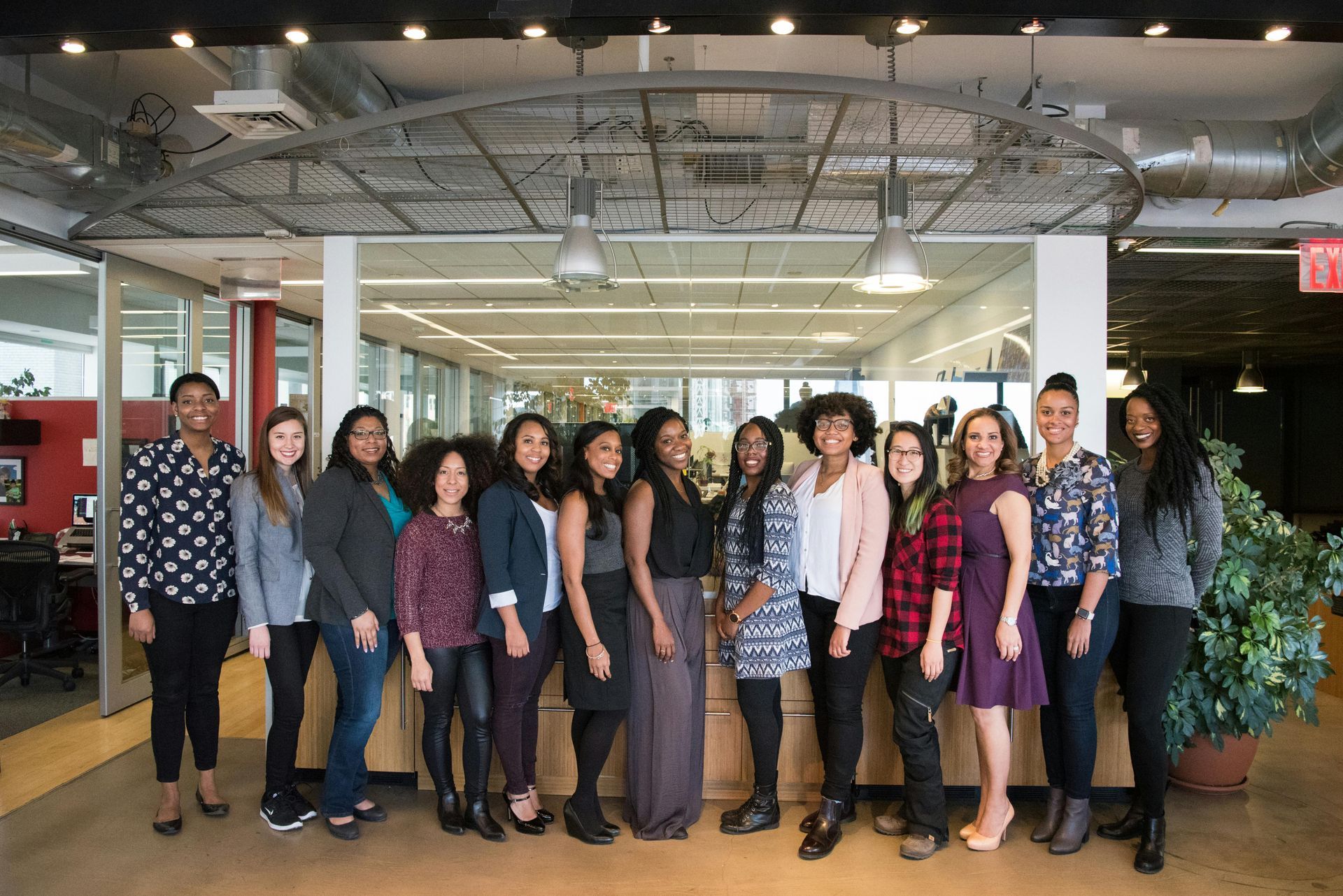 A group of women are posing for a picture in an office.
