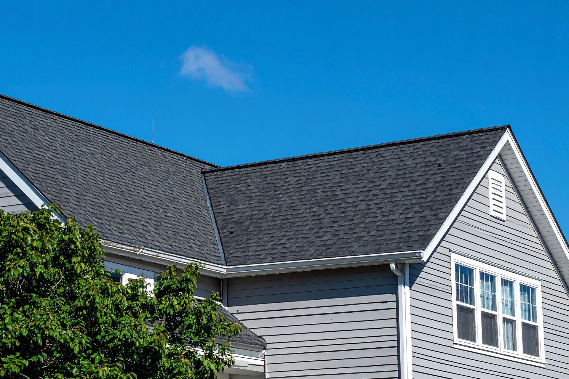 House roof and siding under a bright blue sky
