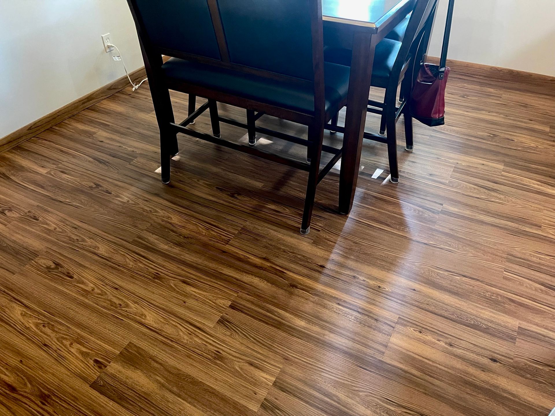 Dining table and chairs on wood-look flooring in a small room